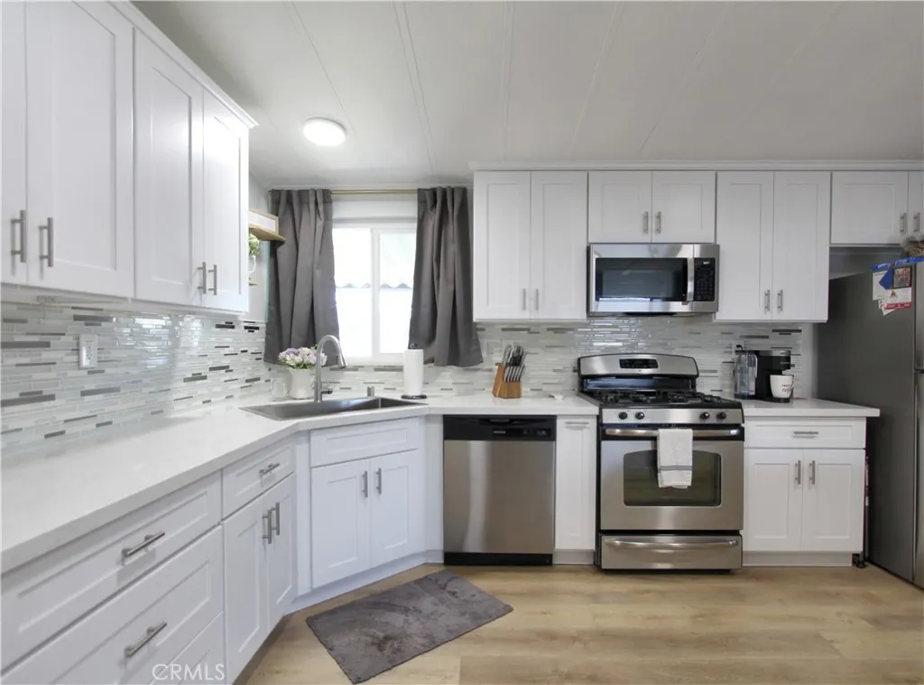 692 North Adele Street, Unit 101 Orange, CA 92867 - Photo 9 of 20 a kitchen with stainless steel appliances granite countertop a sink a stove a refrigerator and cabinets
