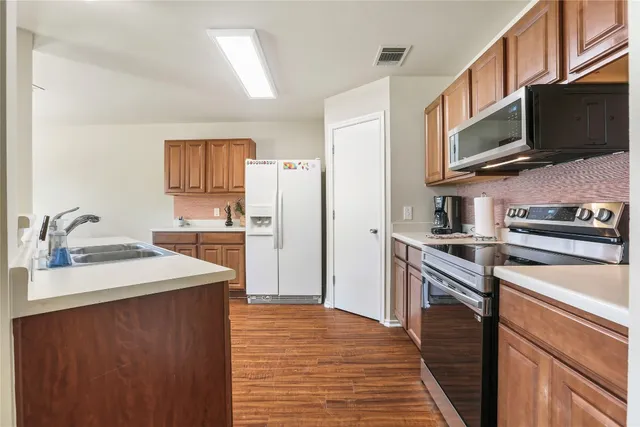 a kitchen with stainless steel appliances a refrigerator stove and microwave