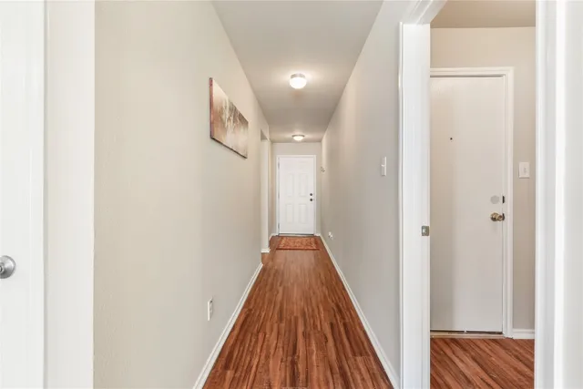 a view of a hallway with wooden floor and staircase