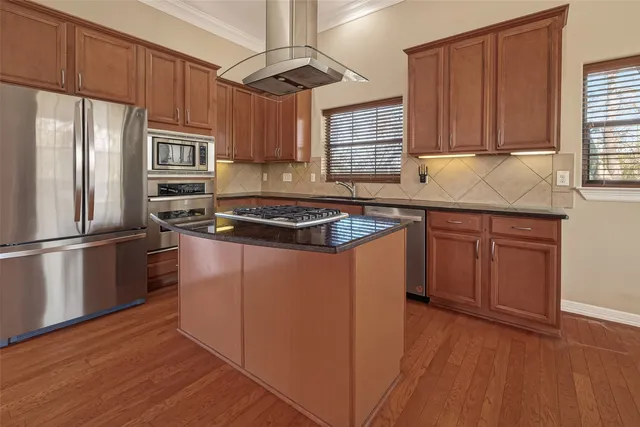a kitchen with stainless steel appliances granite countertop a stove and a wooden floors