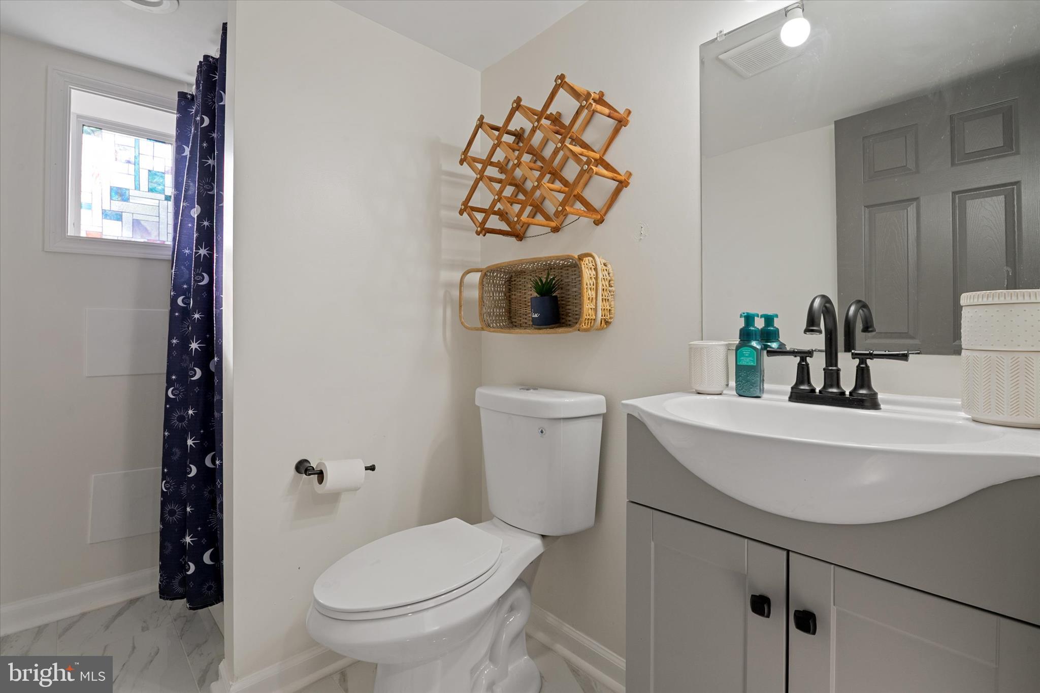 3714 5th Street Baltimore, MD 21225 - Photo 26 of 35 a bathroom with a sink a toilet and mirror