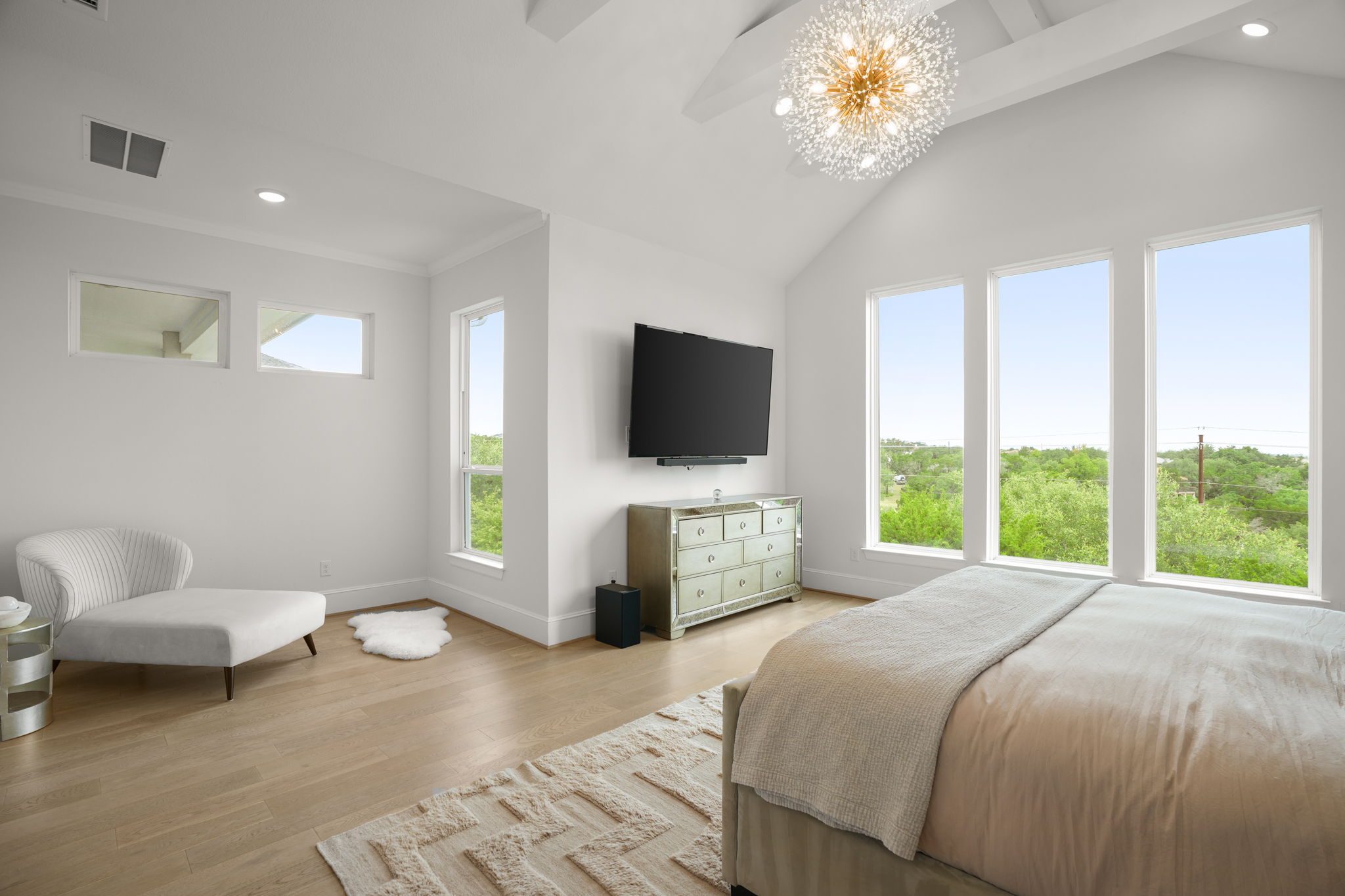 104 Lodestone Cove Austin, TX 78738 - Photo 17 of 40 An airy bedroom showcases soaring vaulted ceilings and generous windows offering sweeping outdoor views.