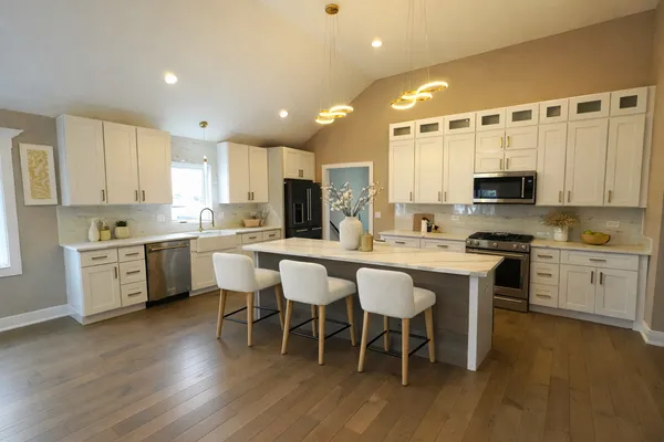 a kitchen with a white cabinets and chairs