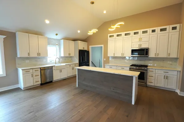 a large kitchen with stainless steel appliances sink a microwave and cabinets