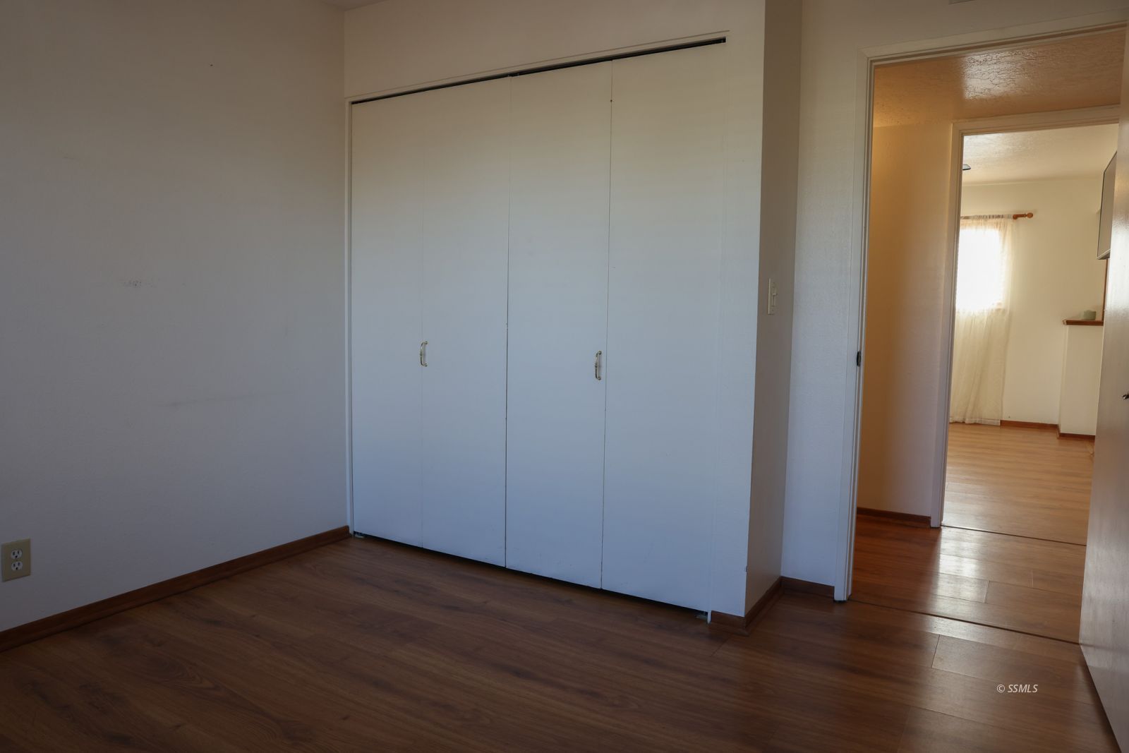 1051 Peg Street Ridgecrest, CA 93555 - Photo 24 of 34 a view of an empty room with wooden floor and a window