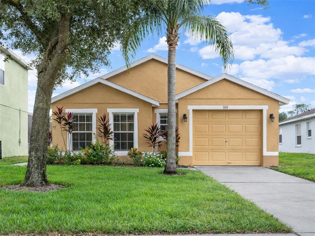 188 Ridgemont Court Davenport, FL 33896 - Photo 2 of 38 a view of a house with a small yard plants and palm trees