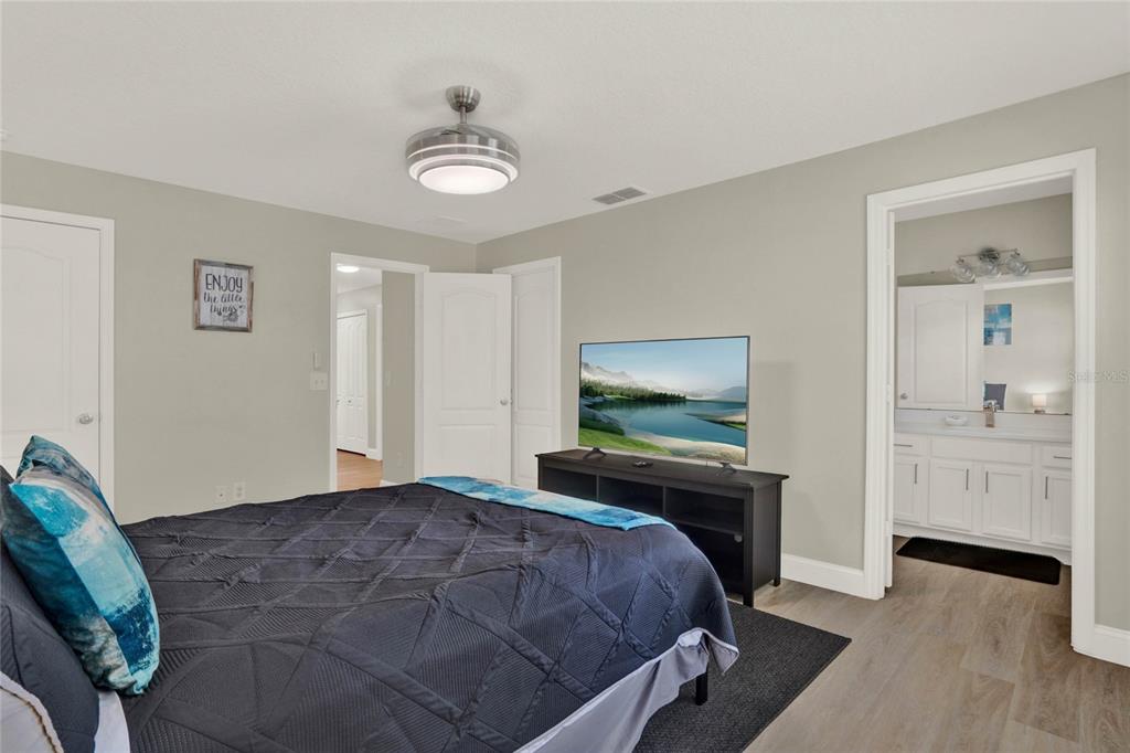 188 Ridgemont Court Davenport, FL 33896 - Photo 24 of 38 a bedroom with a bed and a chandelier