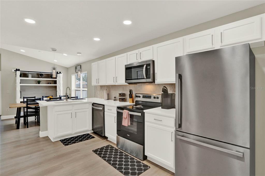 188 Ridgemont Court Davenport, FL 33896 - Photo 3 of 38 a kitchen with stainless steel appliances a refrigerator stove and microwave