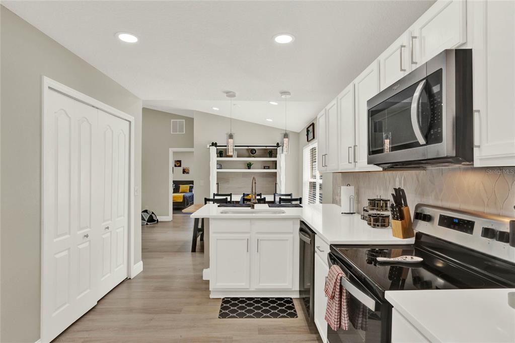 188 Ridgemont Court Davenport, FL 33896 - Photo 4 of 38 a kitchen with stainless steel appliances granite countertop a stove and a microwave