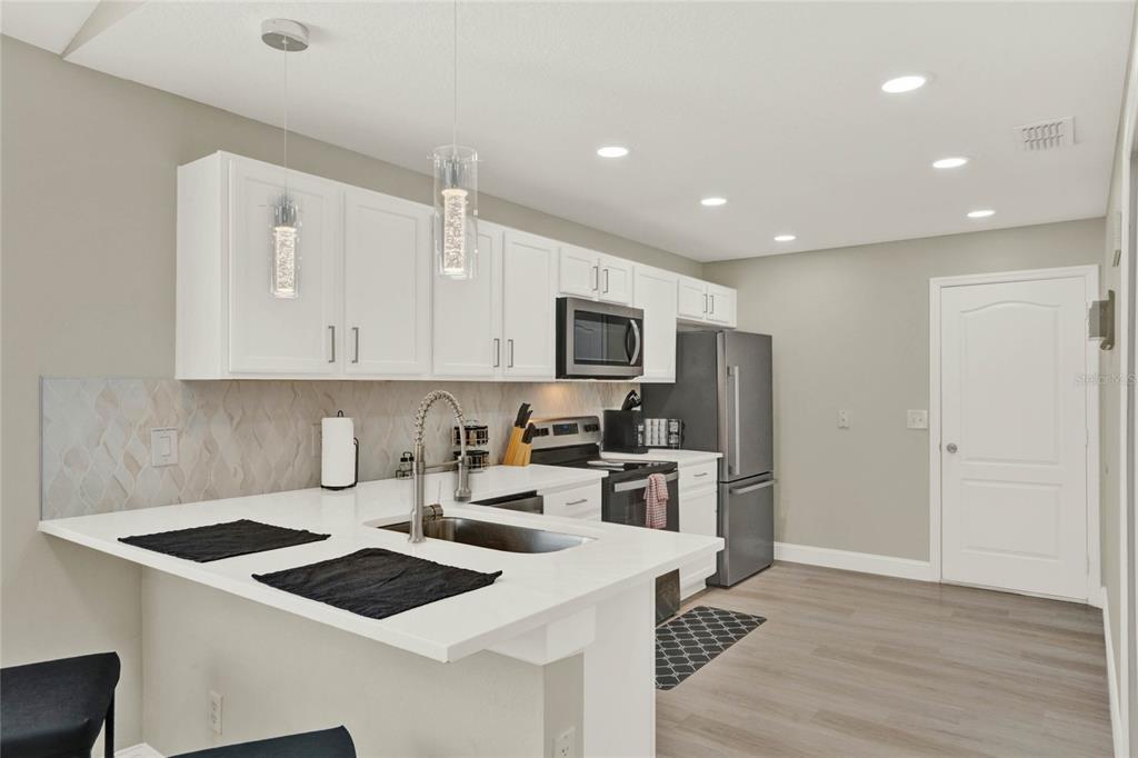 188 Ridgemont Court Davenport, FL 33896 - Photo 5 of 38 a kitchen with granite countertop a sink stove and refrigerator