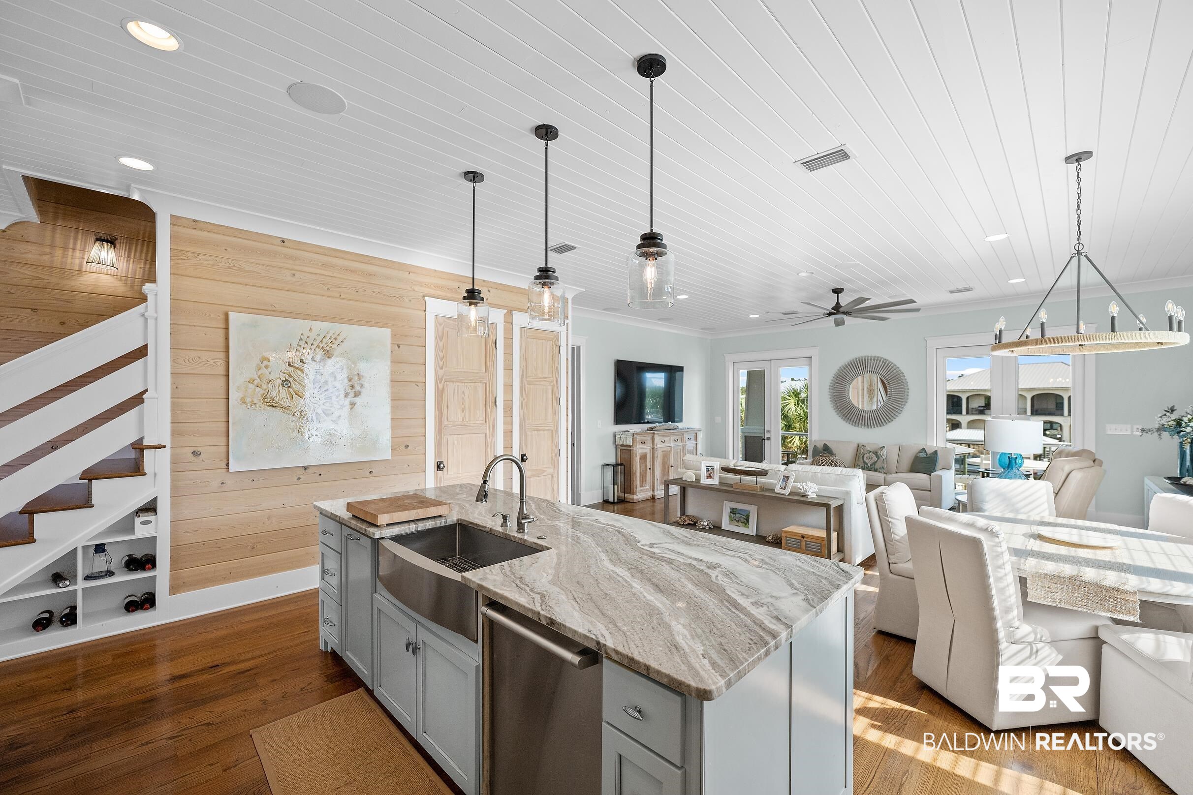 33186 Marlin Key Drive Orange Beach, AL 36561 - Photo 85 of 87 Kitchen featuring light stone countertops, decorative light fixtures, wooden walls, open floor plan, and dark wood-style flooring