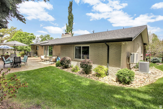 1350 Canyon Park Road Bountiful, UT 84010 - Photo 37 of 38 Expansive backyard featuring a large concrete patio, manicured lawn, and mature landscaping
