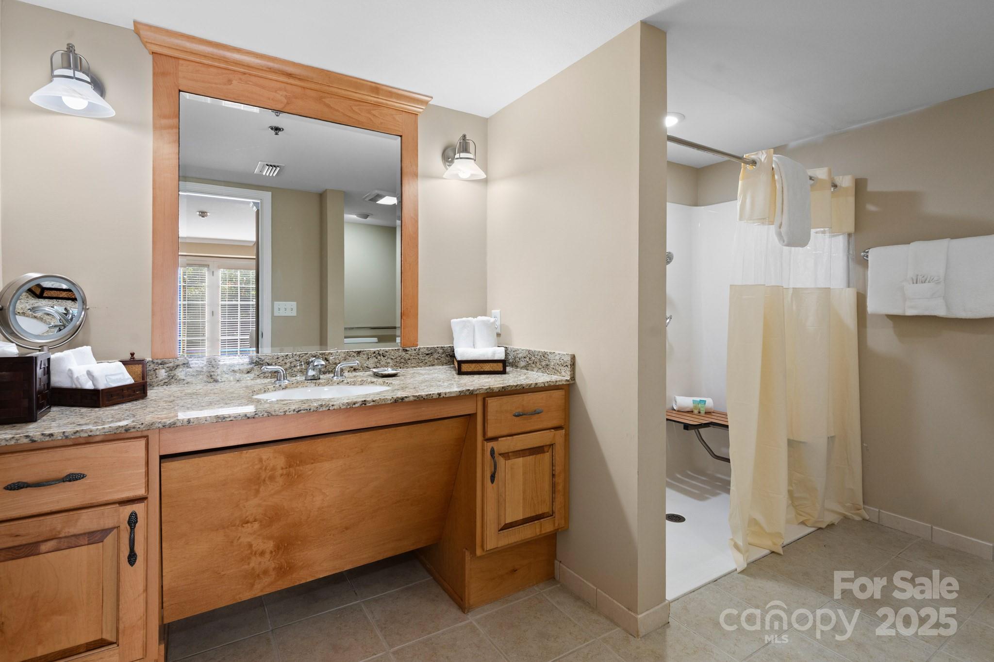 203 Bowling Park Road Asheville, NC 28803 - Photo 12 of 23 a bathroom with a granite countertop sink a mirror and a shower