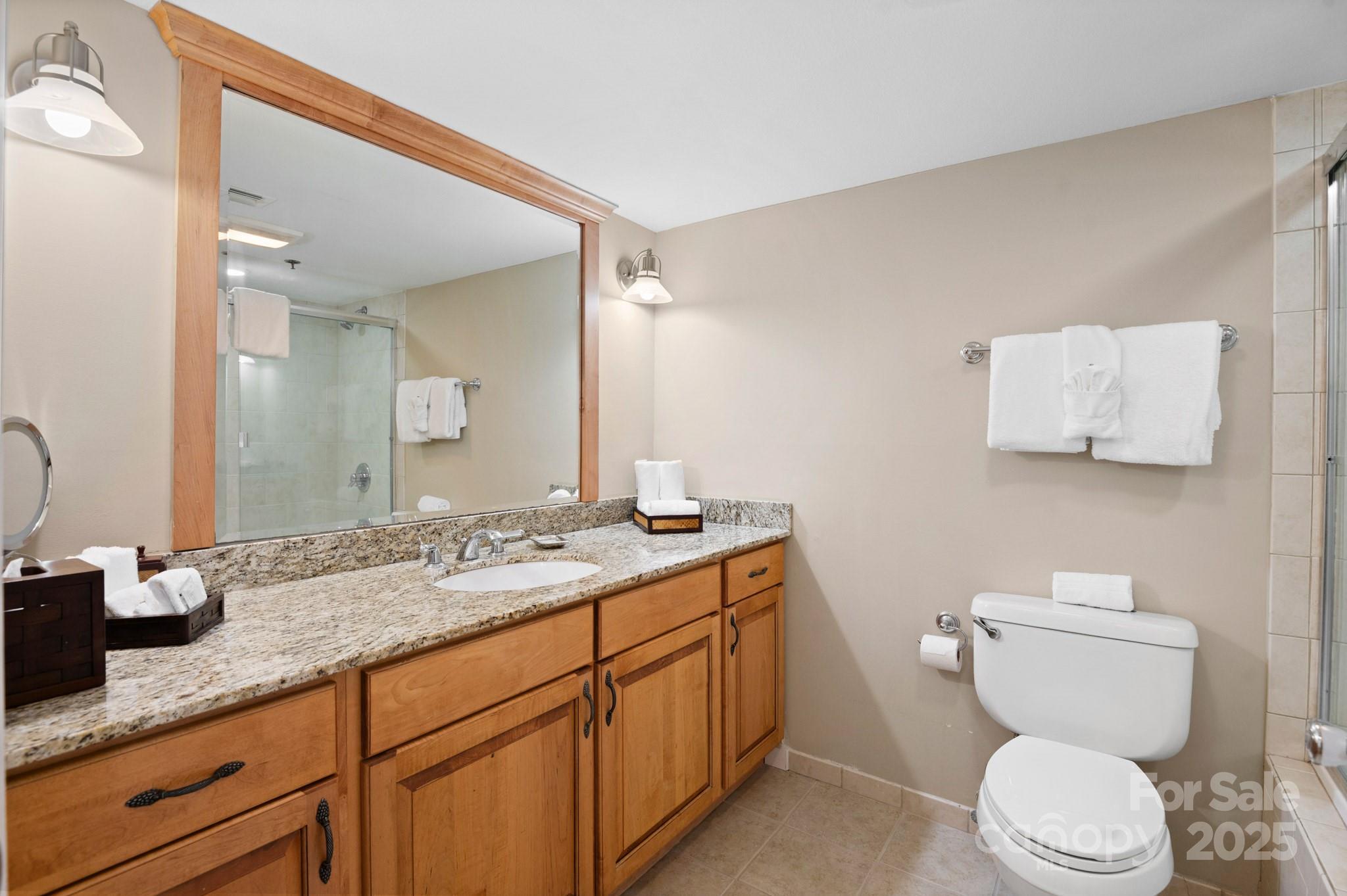 203 Bowling Park Road Asheville, NC 28803 - Photo 16 of 23 a bathroom with a granite countertop toilet sink and mirror