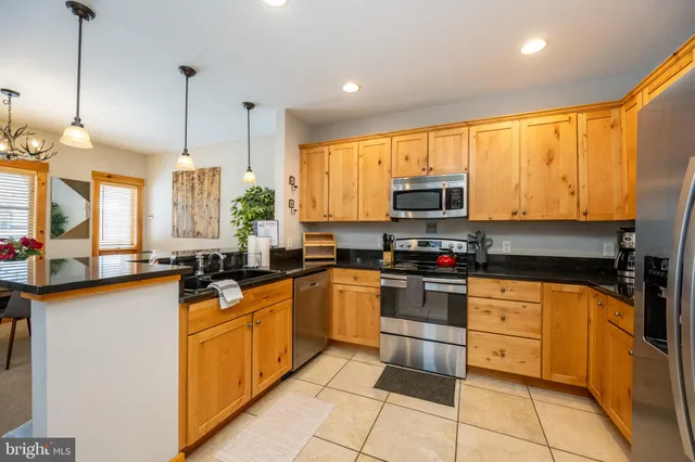 a kitchen with stainless steel appliances granite countertop a refrigerator and a stove