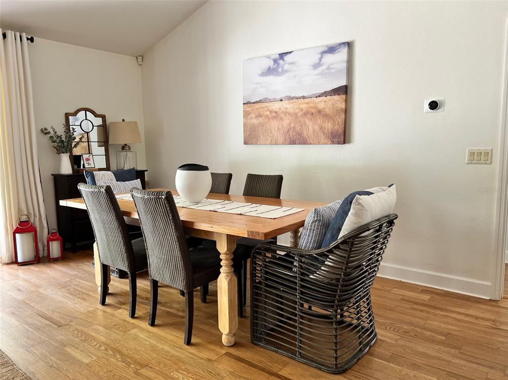 12595 Southeast Sunset Harbor Road Weirsdale, FL 32195 - Photo 3 of 25 a view of a dining room with furniture and wooden floor