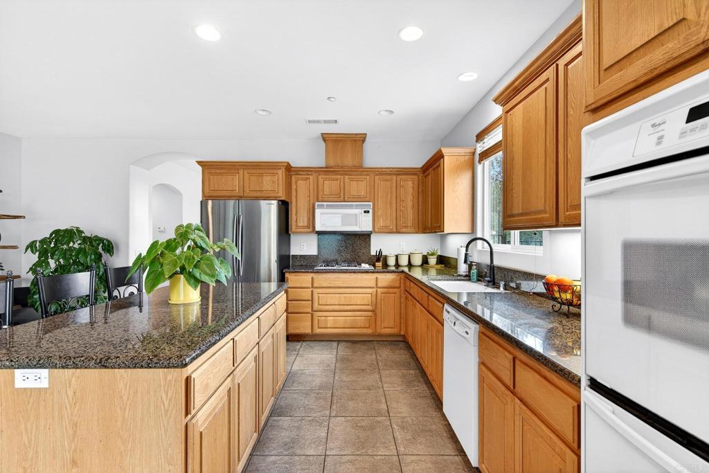 15953 Shalom Road Ramona, CA 92065 - Photo 16 of 71 a kitchen with stainless steel appliances granite countertop sink stove and cabinets