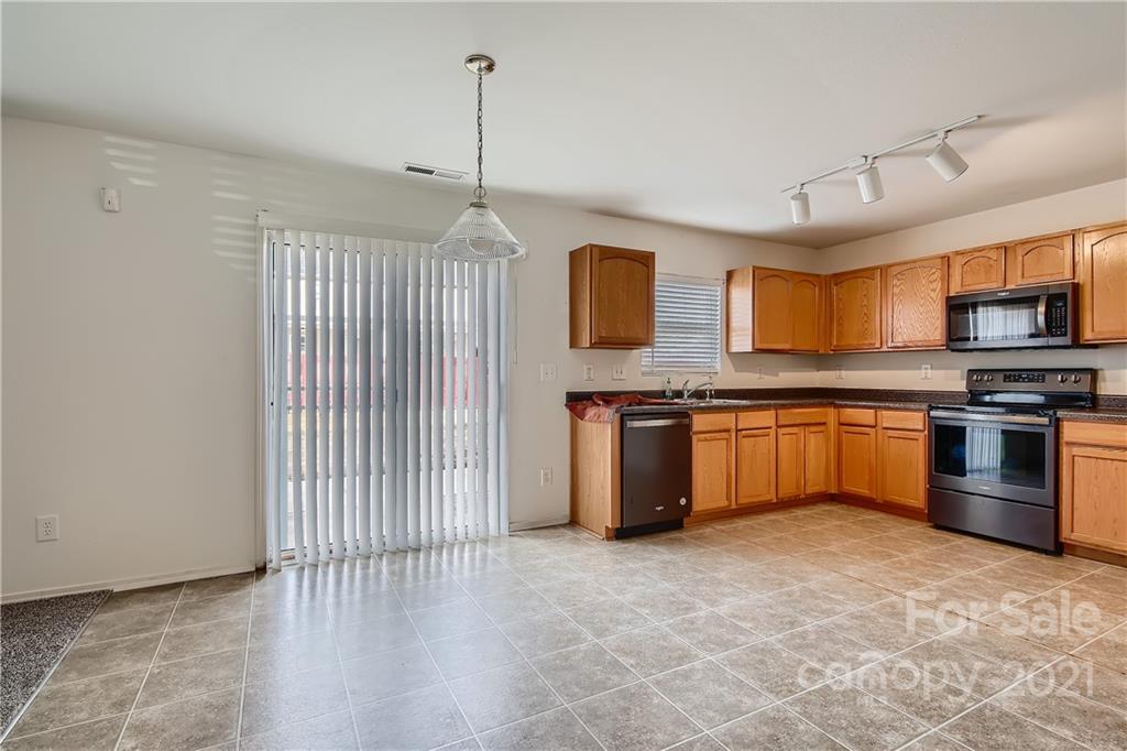 8735 Chalkstone Road Charlotte, NC 28216 - Photo 12 of 29 a kitchen with stainless steel appliances a stove top oven and a sink
