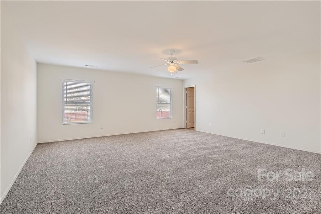 8735 Chalkstone Road Charlotte, NC 28216 - Photo 16 of 29 an empty room with windows and chandelier fan