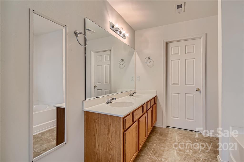 8735 Chalkstone Road Charlotte, NC 28216 - Photo 18 of 29 a bathroom with a sink a mirror and a shower