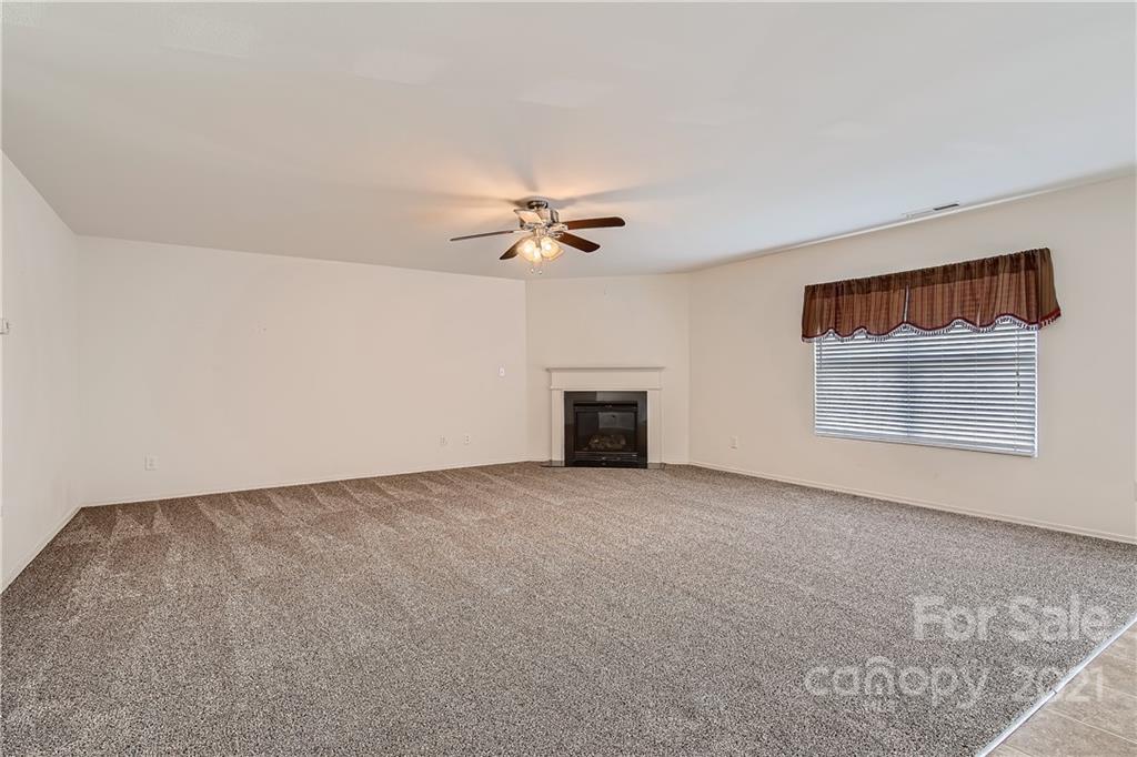 8735 Chalkstone Road Charlotte, NC 28216 - Photo 6 of 29 a view of an empty room with a ceiling fan and window