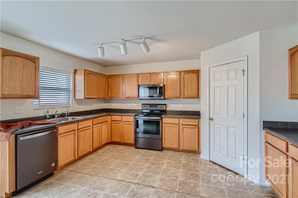 8735 Chalkstone Road Charlotte, NC 28216 - Photo 8 of 29 a kitchen with stainless steel appliances granite countertop a stove sink and cabinets