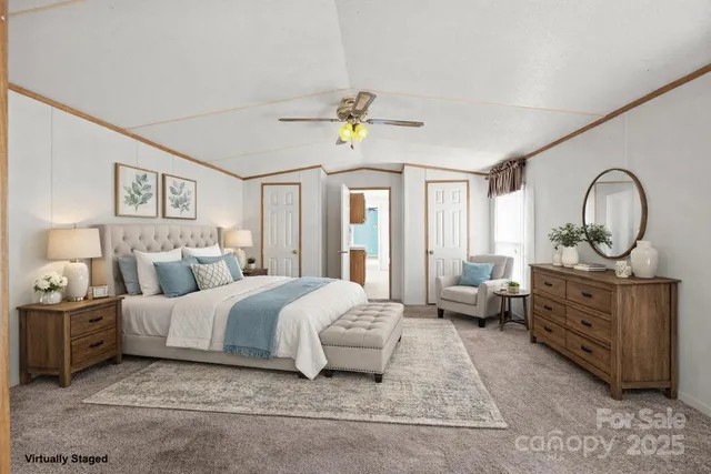 a spacious bedroom with a bed a dresser and large windows