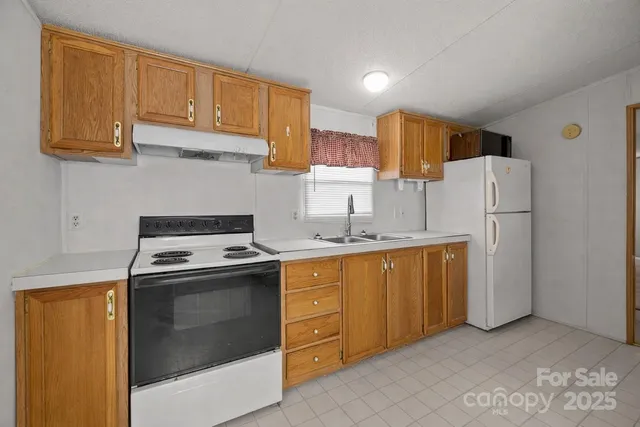 a kitchen with appliances a sink and cabinets
