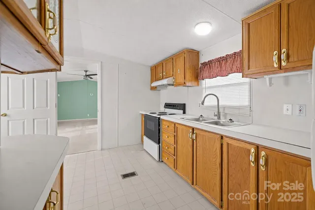 a kitchen with sink a refrigerator and cabinets