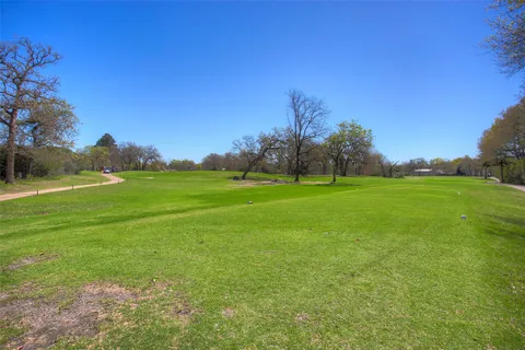 a view of a field with trees in the background