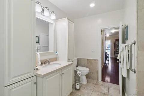 a bathroom with a sink a toilet and shower a mirror