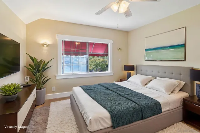 a bedroom with a large bed and a potted plant