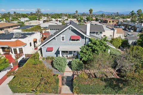 an aerial view of residential houses with outdoor space and trees