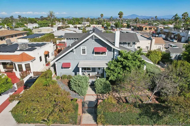 an aerial view of residential houses with outdoor space and trees
