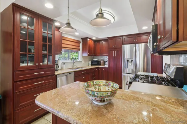 a kitchen with a stove a refrigerator and a dining table with wooden floor