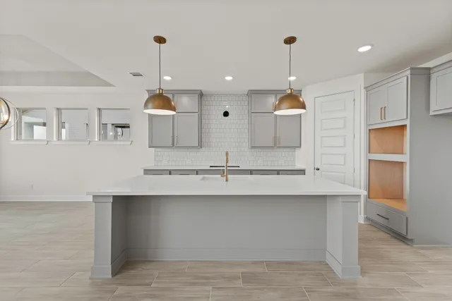 a large kitchen with kitchen island a sink stainless steel appliances and cabinets