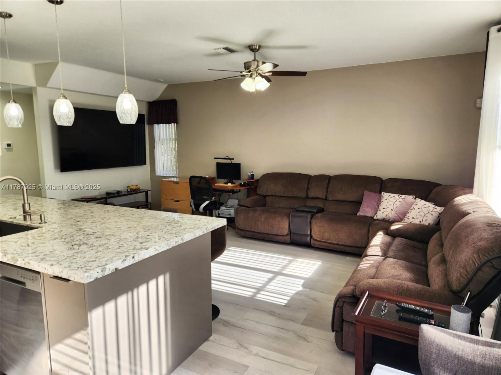 785 Falling Water Road Weston, FL 33326 - Photo 17 of 45 a living room with furniture and a chandelier