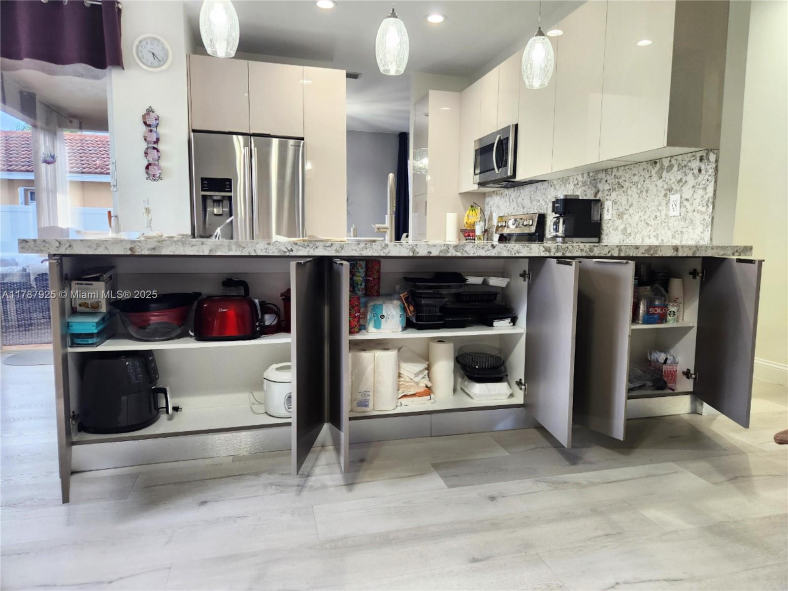 785 Falling Water Road Weston, FL 33326 - Photo 18 of 45 a kitchen with stainless steel appliances kitchen island granite countertop a refrigerator and a stove top oven
