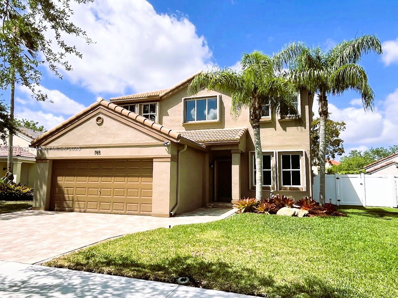 785 Falling Water Road Weston, FL 33326 - Photo 2 of 45 a front view of a house with a yard and garage