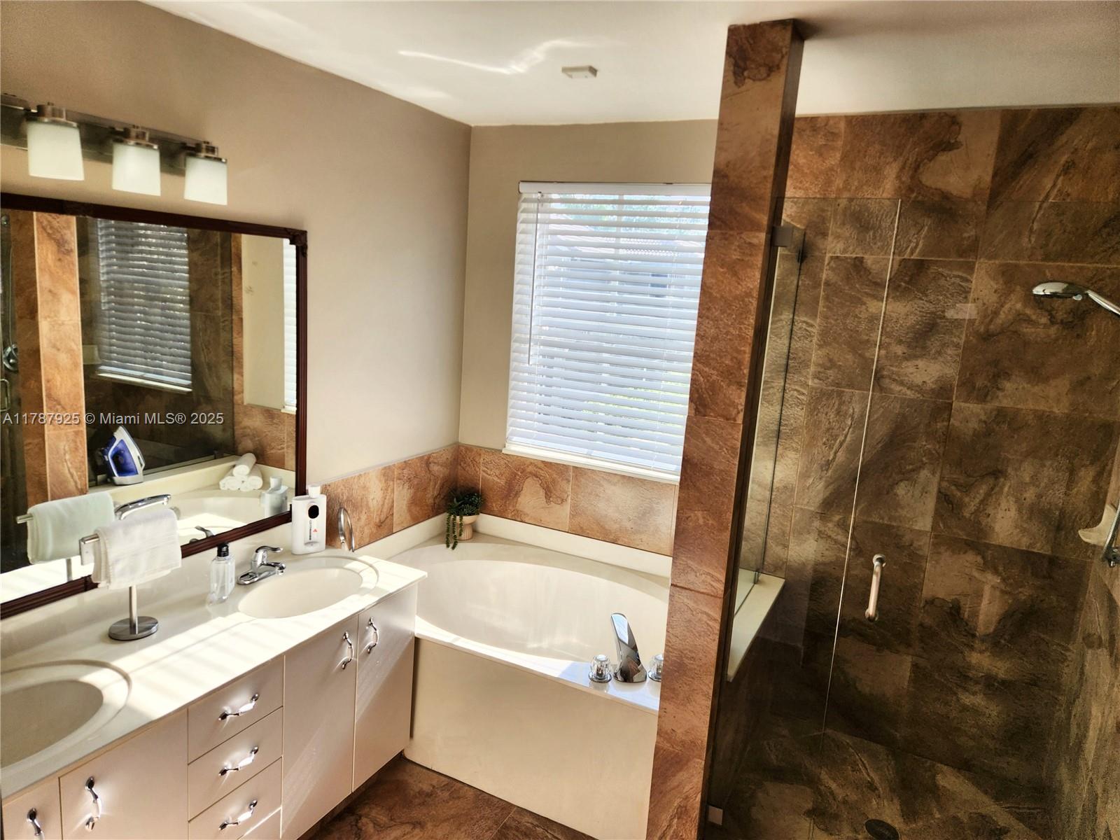 785 Falling Water Road Weston, FL 33326 - Photo 35 of 45 a bathroom with a tub sink and a mirror