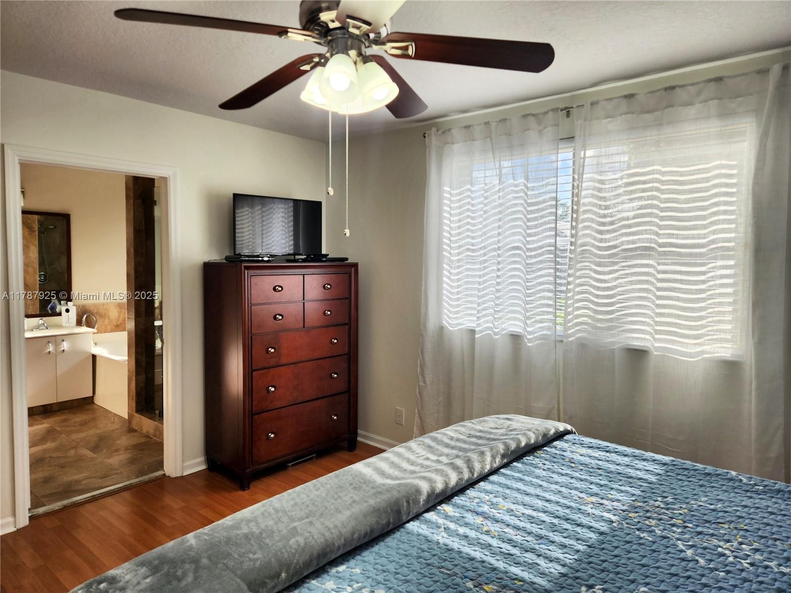 785 Falling Water Road Weston, FL 33326 - Photo 40 of 45 a bedroom with a bed and a chandelier