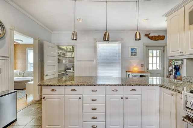 a kitchen with stainless steel appliances granite countertop a sink a stove a refrigerator cabinets and chairs