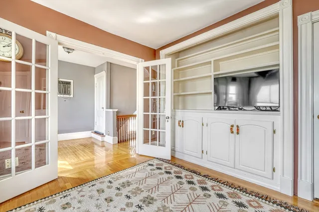 a bedroom with wooden floor and a window