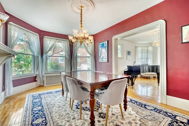 a dining room with furniture a chandelier and wooden floor