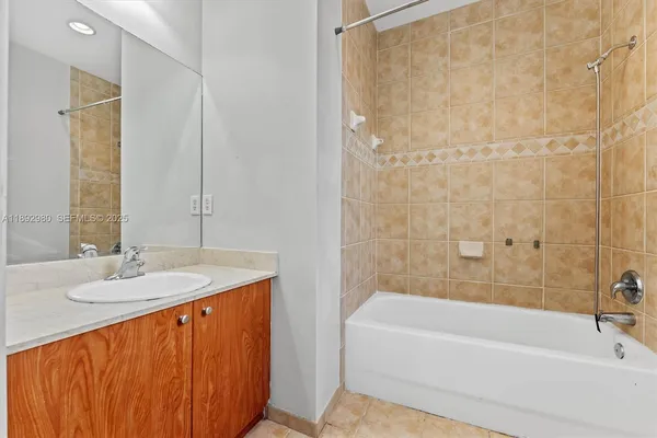 a bathroom with a granite countertop sink and a bathtub