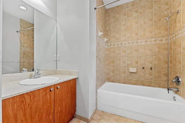 a bathroom with a granite countertop sink and a bathtub