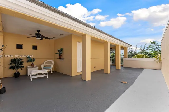 a view of a patio with couple of chairs and potted plants