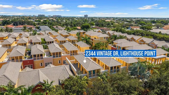 front view of a brick house with a large window and potted plants