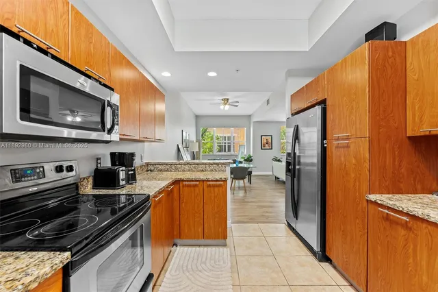 a kitchen with stainless steel appliances granite countertop a refrigerator a stove top oven and a sink