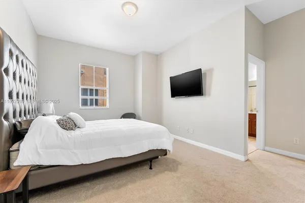 a bedroom with a bed and flat screen tv